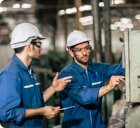 Ingénieur superviseur ouvrier professionnel travaillant en équipe pour former l'exploitation d'une machine dans l'industrie des métaux lourds sales.