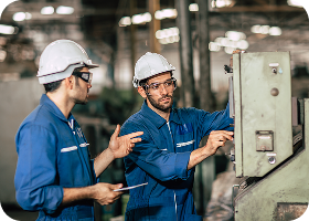 Ingénieur superviseur ouvrier professionnel travaillant en équipe pour former l'exploitation d'une machine dans l'industrie des métaux lourds sales.