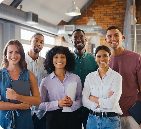 Portrait d'une équipe d'affaires multiculturelle souriante dans un bureau ouvert moderne