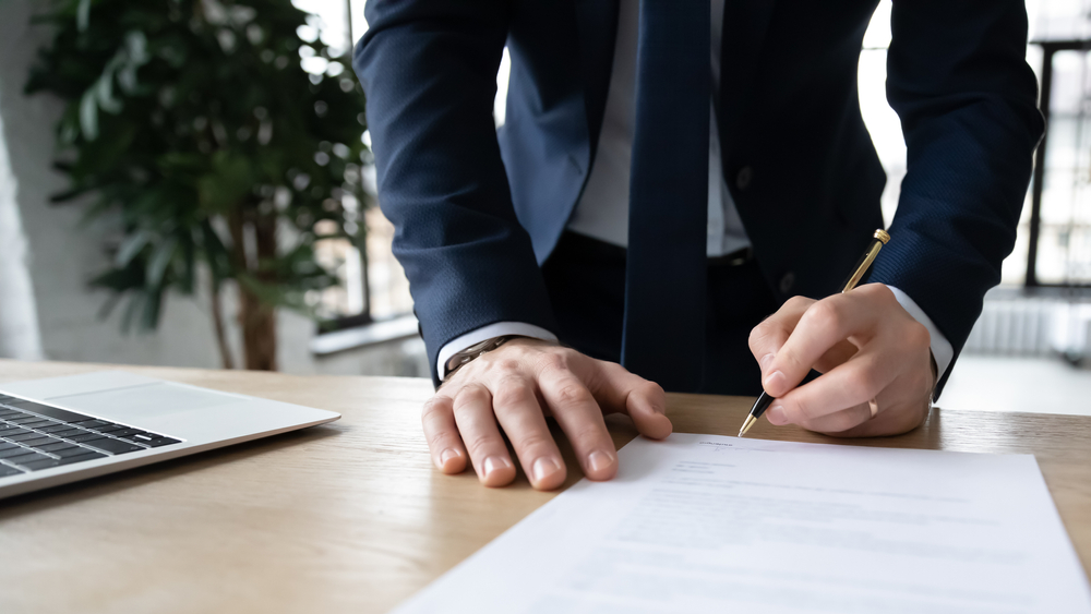 Responsable de l'entreprise, propriétaire d'entreprise, contrat de signature de l'employeur, contrat, rapport papier sur le lieu de travail. Homme d'affaires apposant une signature, embauchant un employé, achetant ou vendant le projet, contrat de clôture.
